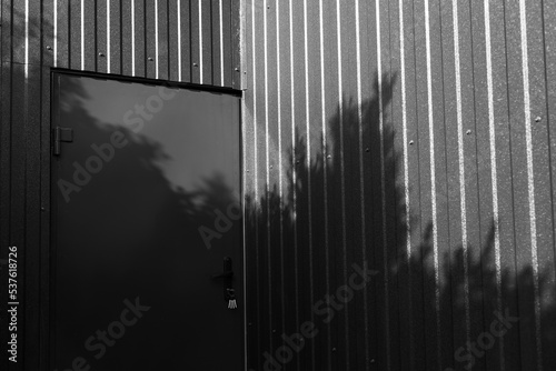 Black and white photo of metal door of metal barnhouse.