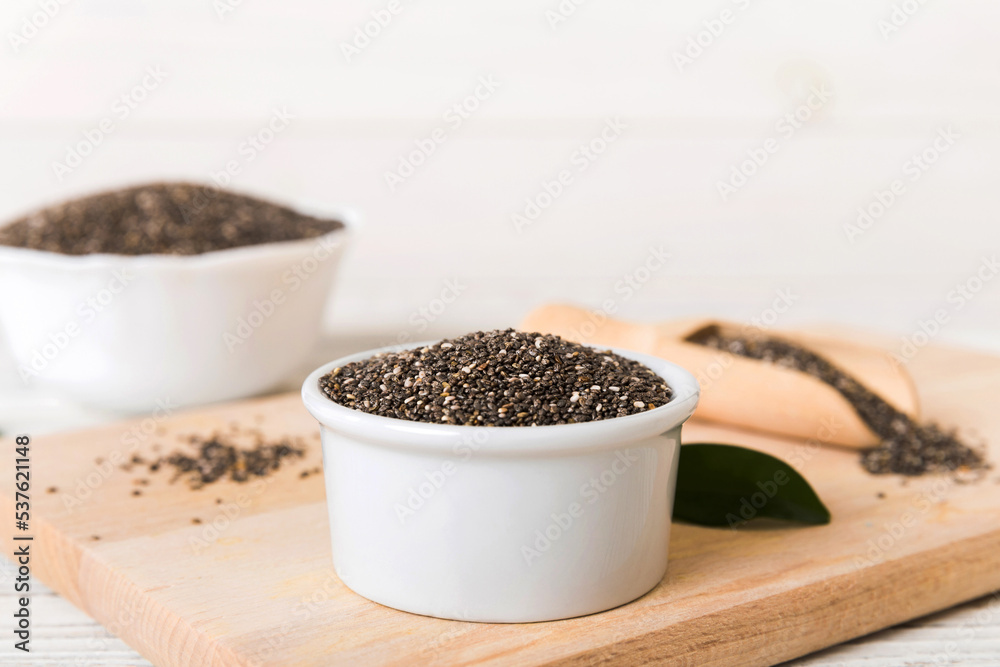 Chia seeds in bowl and spoon on colored background. Healthy Salvia hispanica in small bowl. Healthy superfood Chia seeds in bowl and spoon on colored background. Healthy Salvia hispanica in small bowl. Healthy superfood
