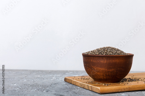 Chia seeds in bowl on colored background. Healthy Salvia hispanica in small bowl. Healthy superfood photo