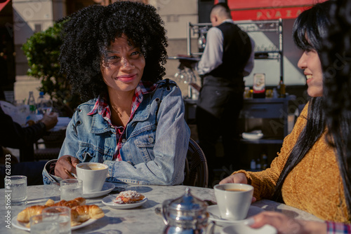 Foto young black Haitian Afro women drinking coffee with their friends in an outdoor
