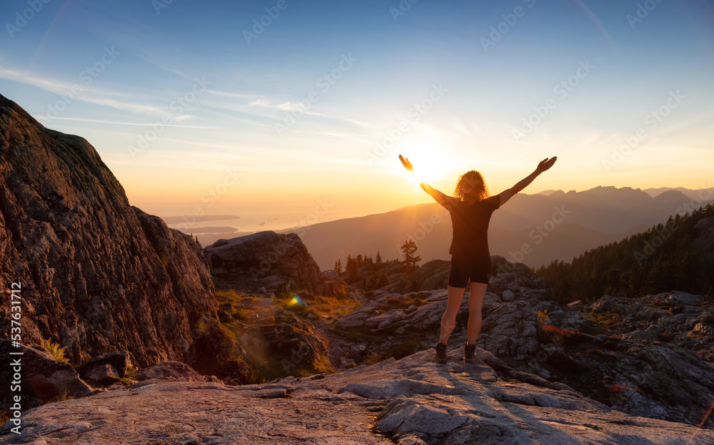 Adventurous Woman Hiker on top of Canadian Mountain Landscape. Sunny Sunset Sky. Top of Mt Seymour near Vancouver, British Columbia, Canada. Adventure Travel Concept Adventurous Woman Hiker on top of Canadian Mountain Landscape. Sunny Sunset Sky. Top of Mt Seymour near Vancouver, British Columbia, Canada. Adventure Travel Concept