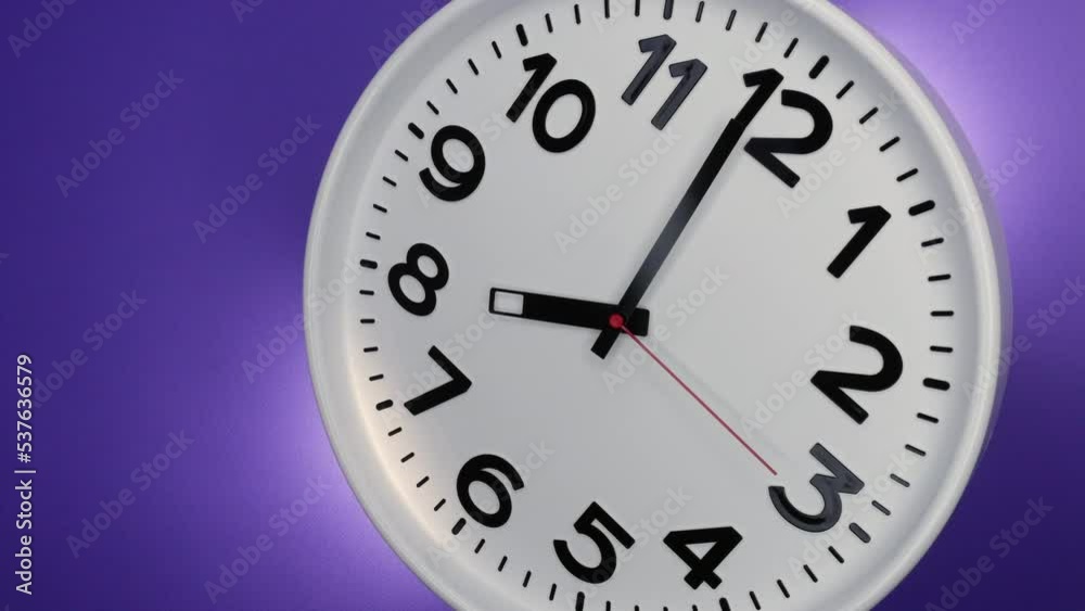 A White Wall Clock On Purple Background With A Time Of 8.00 Am Or Pm. A Black Hands and Red Second Hand Of The Clock. Timelapse.4k. ProRes. A White Wall Clock On Purple Background With A Time Of 8.00 Am Or Pm. A Black Hands and Red Second Hand Of The Clock. Timelapse.4k. ProRes.