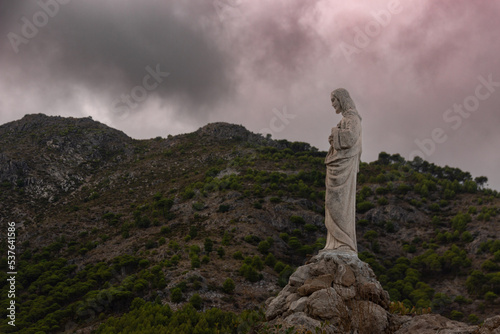 statue of a Christ in Mijas pueblo with mountains skyline in the background