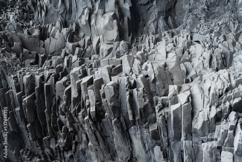 Dramatic rock wall. Textured gray basalt wallpaper background. 