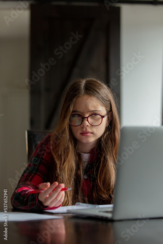 teenage girl trying to study at home on a computer