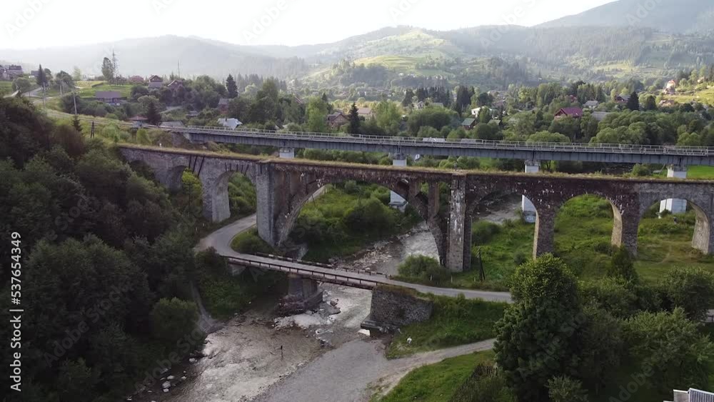 viaduct over the river in the mountains shot by drone. Bridge in mountains viaduct over the river in the mountains shot by drone. Bridge in mountains