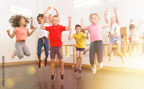 Portrait of satisfied boys and girls jumping having fun after dance class