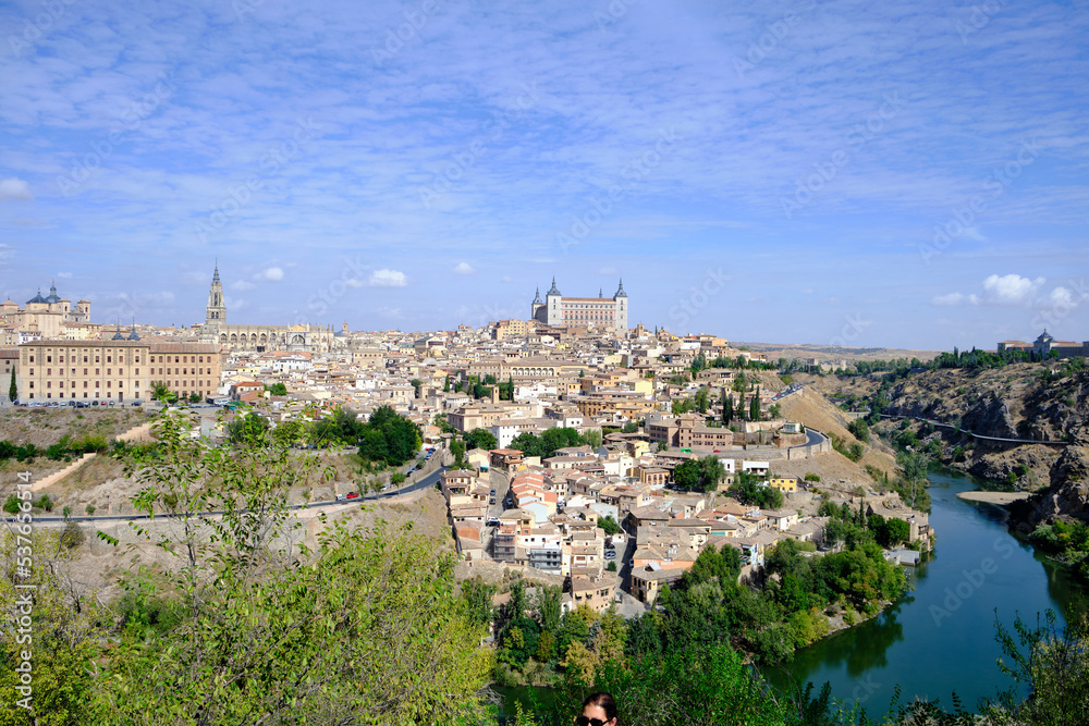 View of Toledo, Spain. It is a World Heritage Site by UNESCO. Famous landmarks such as the Primatial Cathedral of Saint Mary of Toledo, Alcázar of Toledo, and the Tagus River are seen.