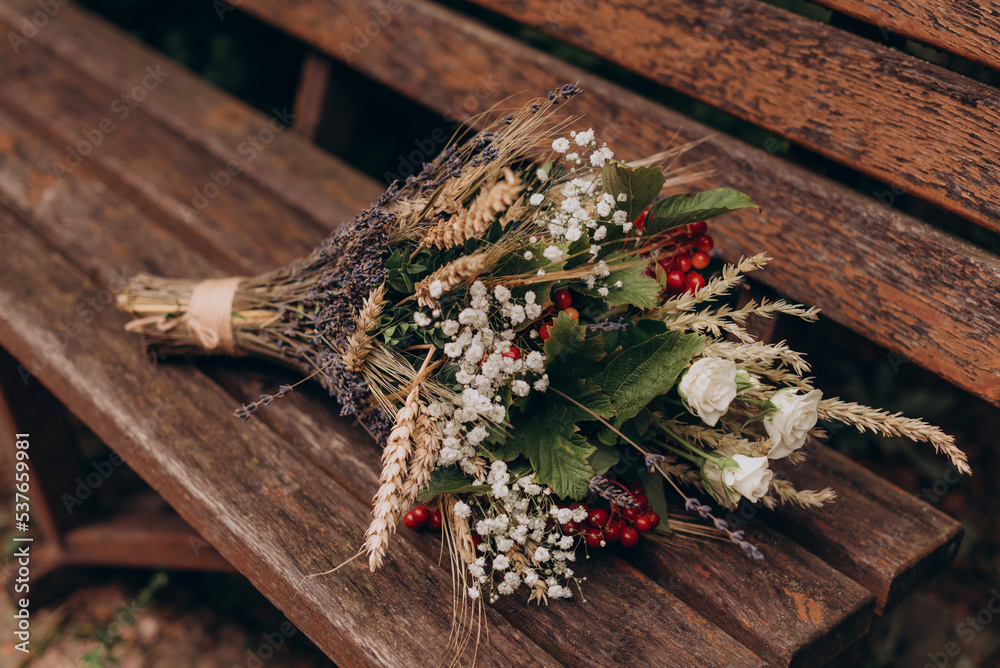 A wedding bouquet with pink and white flowers lies on brown boards
A wedding bouquet with pink and white flowers lies on brown boards