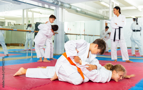 Boy and girl learn to perform painful holds in karate training