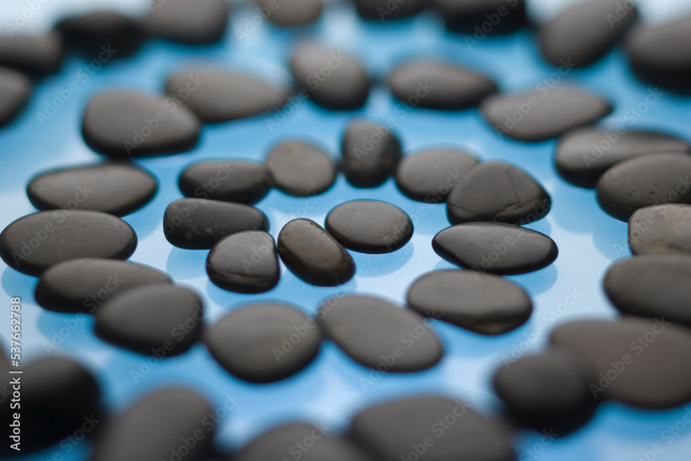 A spiral pathway of stones on a blue background. A spiral pathway of stones on a blue background.