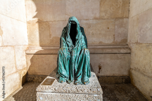 The “Pietá” by Anna Chromy, a statue of a hollow figure wearing a cloak next to the Salzburg Cathedral in the historic old town center of Salzburg, Austria. photo