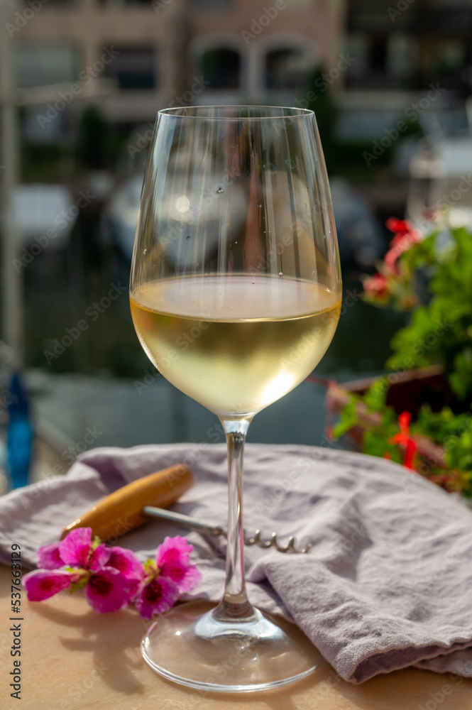 Drinking of cold white wine with view on yacht harbour of Port Grimaud, summer vacation on French Riviera, France Drinking of cold white wine with view on yacht harbour of Port Grimaud, summer vacation on French Riviera, France