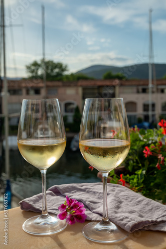 Drinking of cold white wine  with view on yacht harbour of Port Grimaud  summer vacation on French Riviera  France