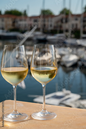 Drinking of cold white wine with view on yacht harbour of Port Grimaud, summer vacation on French Riviera, France