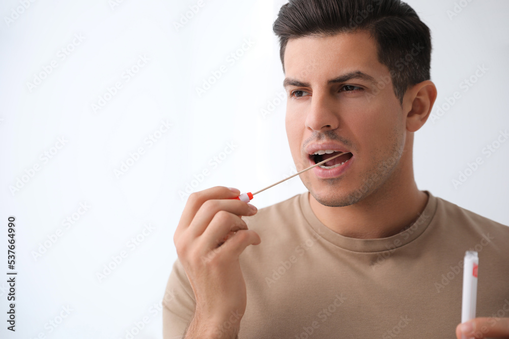 Obraz premium Man taking sample for DNA test on light background