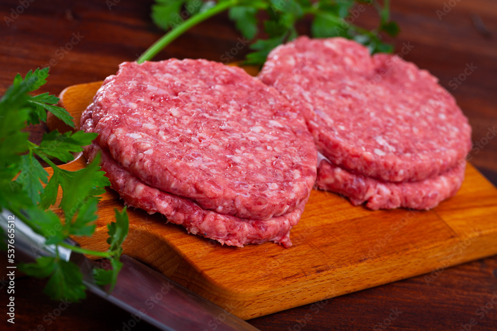 Cooking ingredients, raw burger cutlets on wooden table