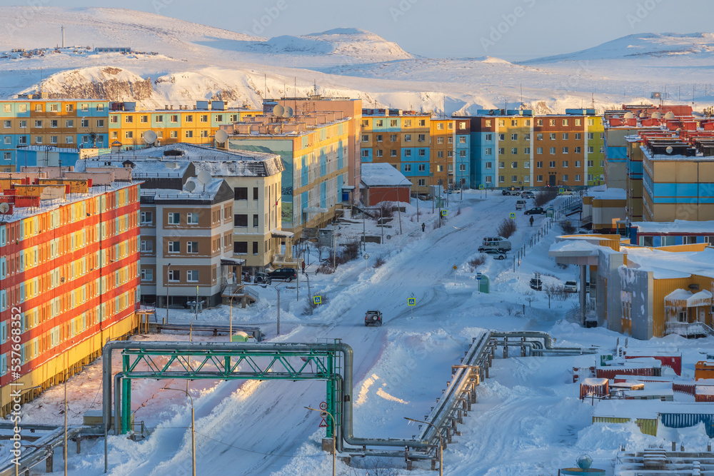 Winter aerial view of a town in the Arctic. A view of the street and colourful houses. Snow-covered tundra in the distance. Cold, frosty weather. Anadyr, Chukotka, Siberia, the Far North of Russia.