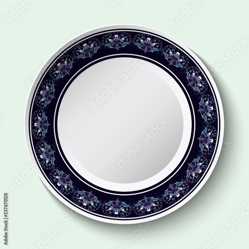 Dark blue circular decor with flowers on the edge of a white ceramic dish. Stylized ethnic cobalt painting on porcelain.