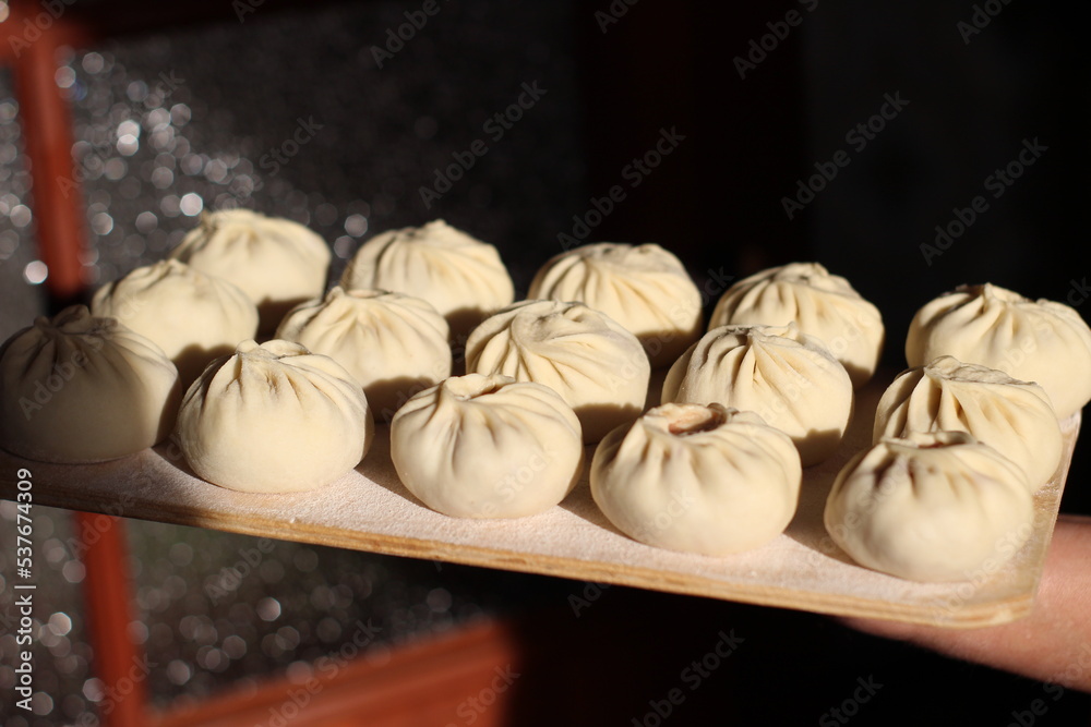 Fototapeta premium Traditional Buryad Cuisine Food with Chopped Meat and Dough. Preparing Making Dumplings Close-up