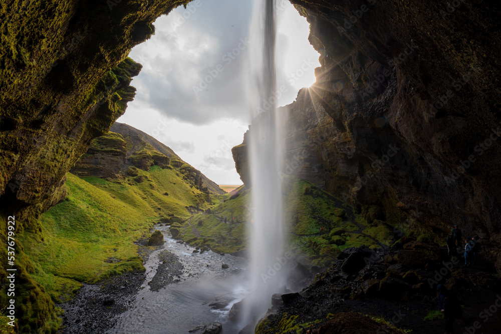 mountain waterfall over a cave