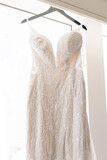 Wedding dress hanging up on a hanger on a window, close-up