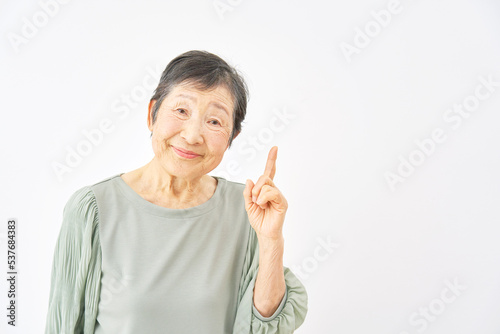 右を指差す高齢女性 白背景