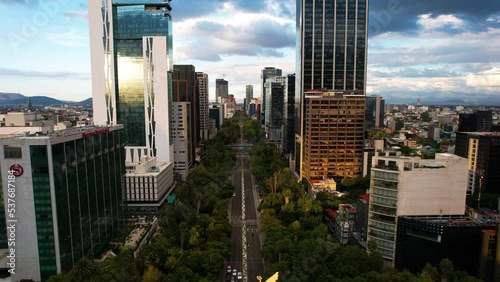 drone shot in descent of a sunset in the paseo de la reforma in mexico city with the view towards the center of mexico city photo