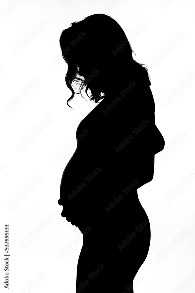 Black silhouette of a young pregnant woman on a white isolated background. Happiness in anticipation of a baby. Vertical.