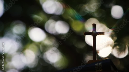 The cross of Jesus Christ shining through the trees and the sunlight shining through the leaves and beautiful sunlight and rays of light
