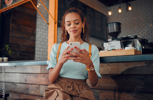 Billede på lærred Phone, social media and coffee shop with a woman typing a text message while sitting in a cafe to relax