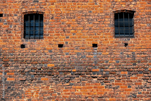 Two windows of red bricks old vintage prison wall.