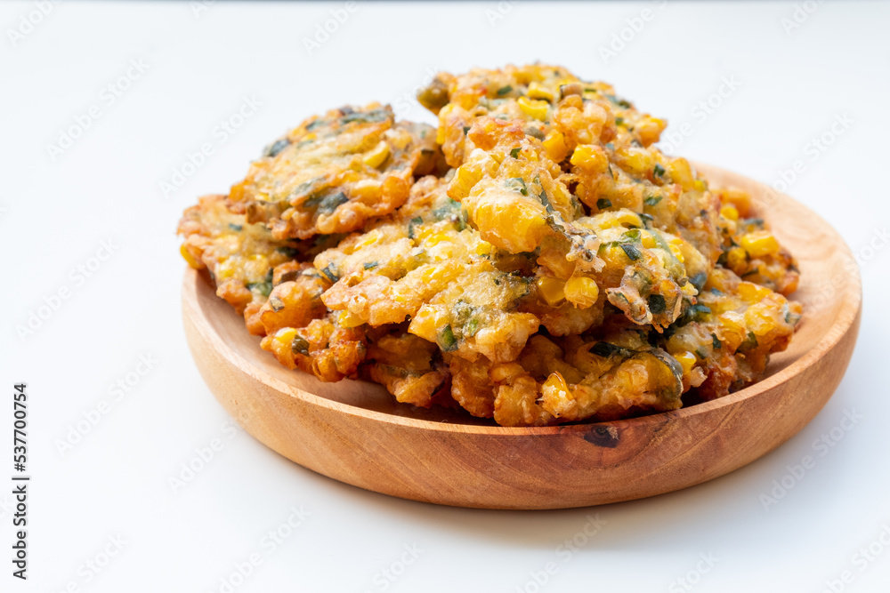 Indonesian Corn Fritters on wooden plate with white background Indonesian Corn Fritters on wooden plate with white background