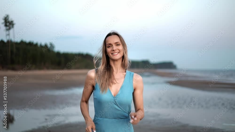 Overjoyed blonde tanned woman smiling running on evening beach summer seacoast landscape slow motion Overjoyed blonde tanned woman smiling running on evening beach summer seacoast landscape slow motion