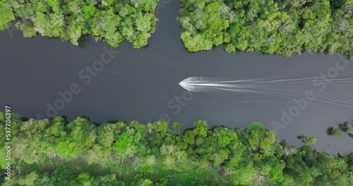 Aerial birdseye dolly left of speedboat navigating waters of Rio Negro, Amazon photo