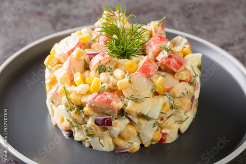 Papier peint Salad with crab meat, corn, red onion, hard-boiled eggs and dill closeup in the plate on the table