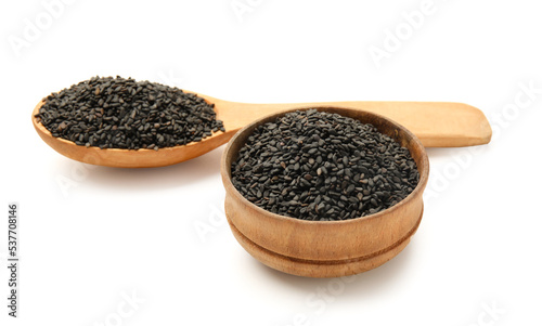 Wooden bowl and spoon of black sesame seeds on white background