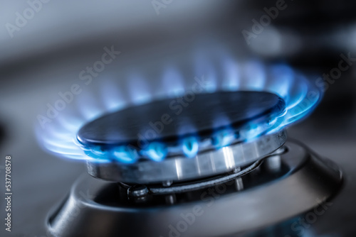 The gas burner burns with the blue flame of a propane butane stove in a home kitchen or hotel restaurant