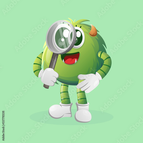 Cute green monster conducting research, holding a magnifying glass