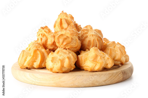 Wooden board with tasty eclairs on white background