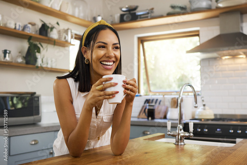Happy woman, coffee or tea in home kitchen and relax with a smile in the morning at house. Calm young person, smiling at peace and tea drink to wake up to start day with positive joyful thoughts