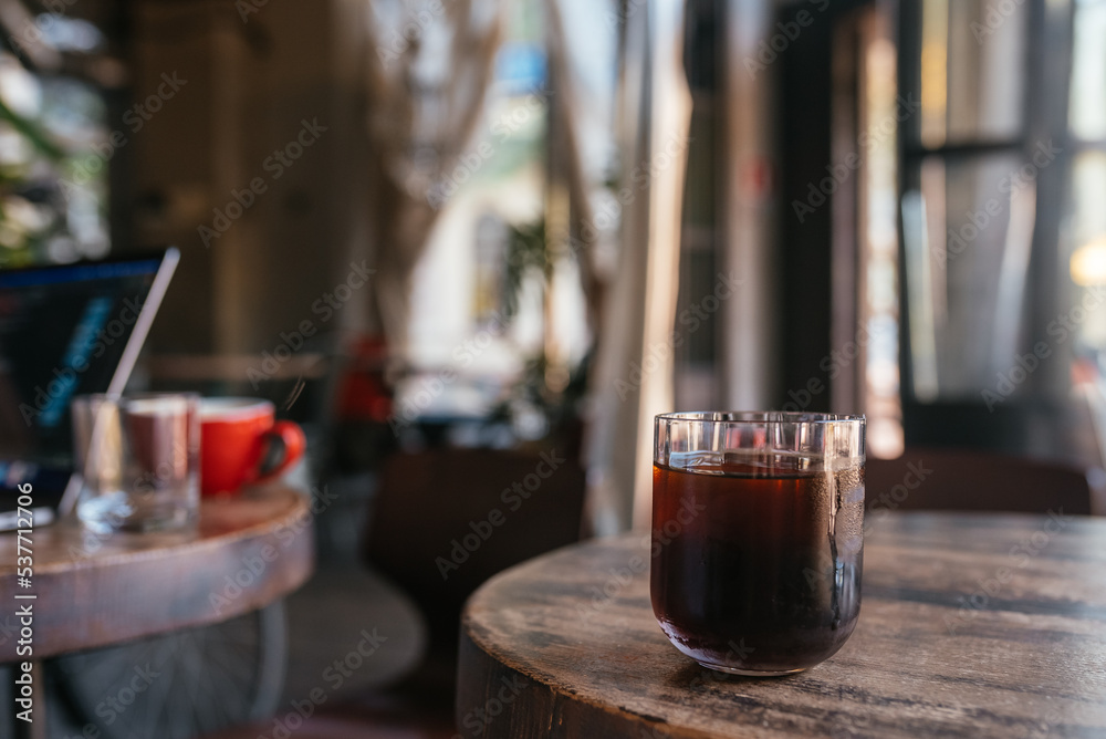 glass with tea on a wooden table, blurred background