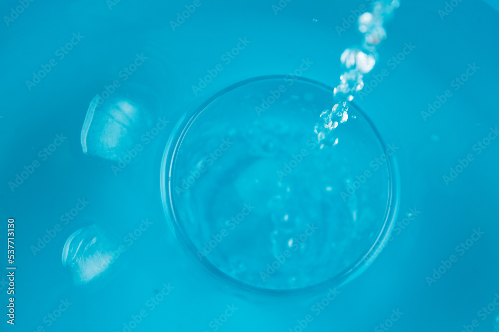 Glass of water on blue background