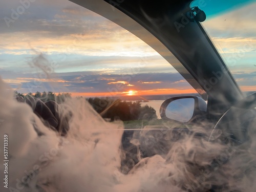 Man smoking a cigarette at the wheel of a car.