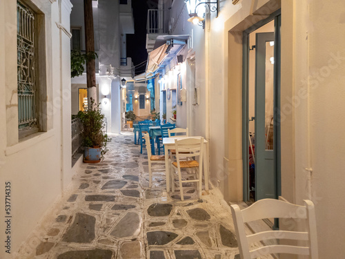 Greek outdoors tavern restaurant at Tinos island, Chora town Cyclades Greece. Illuminated lampposts. photo