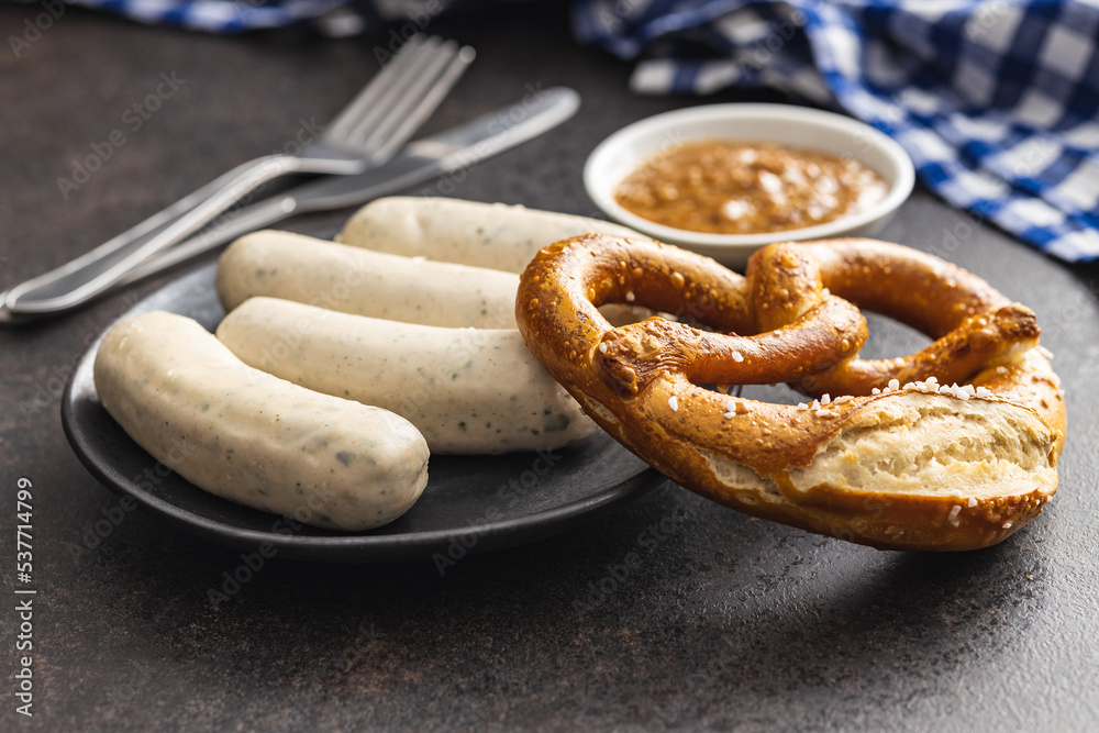Traditional Bavarian white sausages on plate and pretzes. Traditional Bavarian white sausages on plate and pretzes.