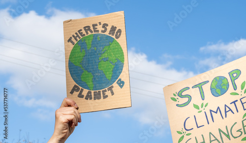 Protesters holding signs with slogans There's no planet B and Stop Climate Change. People with placards at protest rally demonstration, strike against global warming.