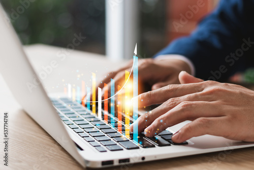 Concept of business growth and financial investment, executives use laptop computers to analyze sales data and economic growth graphs, business planning and strategy.