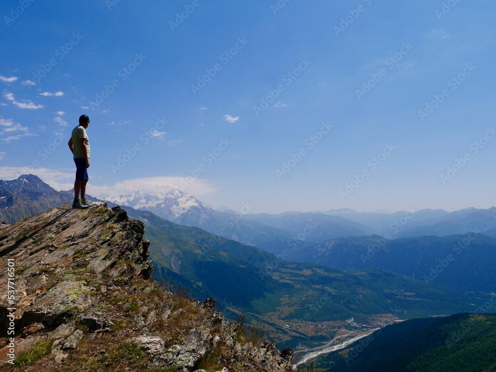 Man hiking at Koruldi lakes. Hiker enjoying beautiful view of Great Caucasus mountains close to Mestia in Upper Svaneti, Georgia.