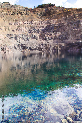 Flooded quarry in the mountains. Location for mining. Beautiful turquoise lake. Kyrgyzstan, Ak-Tuz.
